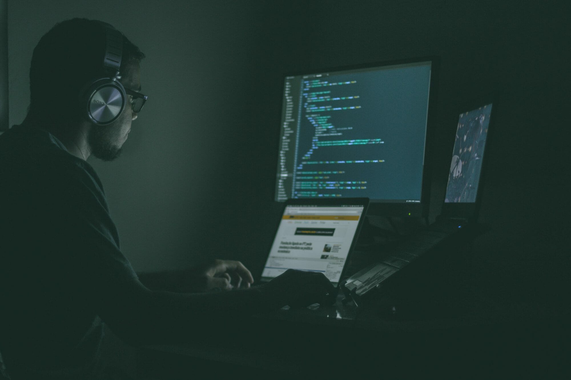 Hacker staring at computer screen in dark room